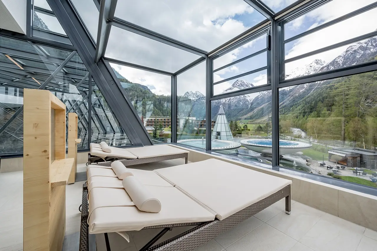 Circondato da oltre 250 vette che superano i tremila metri nella spettacolare valle dell’Ötztal, AQUA DOME – Tirol Therme Längenfeld si inserisce in uno dei paesaggi alpini più suggestivi del Tirolo. Qui, dove la natura domina con la sua imponenza e il ritmo delle montagne invita a rallentare, prende forma uno dei più grandi e innovativi centri termali dell’arco alpino. Con oltre 20.000 metri quadrati dedicati al wellness, dodici piscine interne ed esterne, undici saune e bagni turchi, ampie aree fitness e diversi ristoranti, il resort offre un universo di esperienze pensate per rigenerare corpo e mente in profondità.
AQUA DOME compie un ulteriore passo avanti nel mondo del benessere annunciando il nuovo concetto di “Thermal Longevity”, un approccio olistico che guarda al benessere non più soltanto come momento di relax, ma come percorso consapevole verso una vita più lunga e soprattutto più sana. Alimentazione equilibrata, attività fisica mirata, trattamenti personalizzati e attenzione alla salute mentale si intrecciano con la forza rigenerante dell’acqua termale di Längenfeld, creando un programma che si fonda su principi scientifici e su una visione moderna della salute. L’obiettivo non è semplicemente aggiungere anni alla vita, ma aggiungere qualità, energia e vitalità al tempo che viviamo, rallentando i processi di invecchiamento e riscoprendo un equilibrio profondo tra corpo e mente.
All’interno di questa visione si inseriscono anche importanti novità strutturali, pensate per rendere l’esperienza termale ancora più immersiva e raffinata. Tra queste spicca una nuova sauna nel cuore del tempio della Spa, cinque eleganti sale relax premium progettate per garantire maggiore privacy e comfort individuale e un rituale dell’Aufguss completamente rinnovato, ideato in esclusiva per AQUA DOME. Anche il suggestivo “duomo termale”, il cuore architettonico del resort, è stato oggetto di un restyling: le nuove pareti dalle linee morbide e ondulate evocano il movimento naturale dell’acqua, creando un ambiente che trasmette immediatamente una sensazione di armonia e calma interiore.
In questo luogo l’esperienza del benessere nasce dall’incontro perfetto tra architettura contemporanea, paesaggio alpino e la forza primordiale dell’acqua termale, che sgorga da una profondità di 1.865 metri con una temperatura di circa 40 gradi. È proprio questo dialogo tra natura e design a rendere AQUA DOME un luogo unico, dove ogni elemento contribuisce a creare un’atmosfera di profonda rigenerazione.
Le temperature miti rendono particolarmente piacevoli le escursioni e le uscite in bicicletta organizzate dalle quattro guide del resort, che accompagnano gli ospiti alla scoperta degli angoli più suggestivi della valle. Grazie alla loro conoscenza del territorio è possibile esplorare paesaggi autentici, piccoli sentieri nascosti e panorami spettacolari che solo chi vive la montagna ogni giorno sa raccontare.
L’Ötztal offre oltre 1.600 chilometri di percorsi tra boschi, pascoli alpini e spettacolari scenari montani. Per chi desidera muoversi su due ruote è disponibile anche una flotta di biciclette del resort, perfetta per escursioni guidate o per esplorazioni individuali. Dopo una giornata trascorsa nella natura, il ritorno alle terme diventa quasi un rituale: immergersi nelle acque calde, lasciarsi avvolgere dal vapore delle saune e ritrovare lentamente un ritmo più lento e armonioso.
Dopo un importante intervento di ampliamento e rinnovamento, l’area saune dell’AQUA DOME si presenta oggi con un volto completamente nuovo, ancora più orientato alla qualità dell’esperienza e al comfort degli ospiti.
Il cuore dell’innovazione dell’AQUA DOME è rappresentato dai nuovi programmi Thermal Longevity Retreat, pensati per chi desidera intraprendere un percorso concreto verso uno stile di vita più sano e consapevole.
Gli ospiti possono scegliere tra due format: il Kick-off Retreat, della durata di due notti, ideale per un primo approccio alla filosofia della longevity, oppure il Deep Dive Retreat, un programma più completo di cinque notti pensato per chi desidera approfondire il percorso di trasformazione personale.
Entrambi i programmi si basano su un approccio scientifico e altamente personalizzato che integra diversi elementi: analisi del respiro e del metabolismo attraverso la diagnostica uVida, consulenze individuali con longevity coach, strategie su misura per alimentazione, allenamento e gestione dello stress, oltre a trattamenti termali e attività rigeneranti. Il tutto è amplificato dall’effetto benefico dell’acqua termale di Längenfeld, che diventa parte integrante del processo di rigenerazione.
All’AQUA DOME anche la gastronomia diventa parte integrante del percorso di benessere. La tradizione culinaria dell’arco alpino incontra infatti i principi dell’alimentazione orientata alla longevità, dando vita a una proposta gastronomica che unisce gusto, equilibrio nutrizionale e sostenibilità.
L’eccellenza dell’AQUA DOME nel settore del wellness è stata recentemente confermata da uno dei più prestigiosi riconoscimenti internazionali del settore. Il resort ha infatti ricevuto il titolo di “World’s Best Mineral & Hot Springs Spa 2024” ai World Spa Awards, che lo consacra come miglior resort termale dell’arco alpino. Un premio che testimonia la qualità dell’offerta e la costante ricerca di innovazione, e che rappresenta allo stesso tempo uno stimolo a continuare a sviluppare nuove esperienze dedicate al benessere, alla salute e alla qualità della vita.